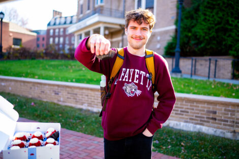 A student smiles, holding a cupcake.