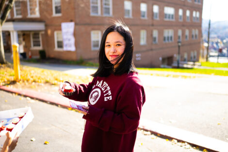 A student smiles, holding a cupcake.