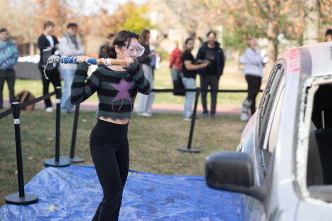 A student uses a sledgehammer on the Lehigh car.