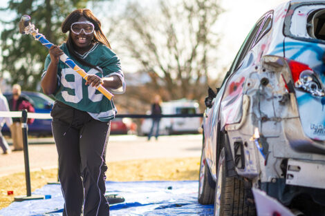 A student uses a sledgehammer on the Lehigh car.