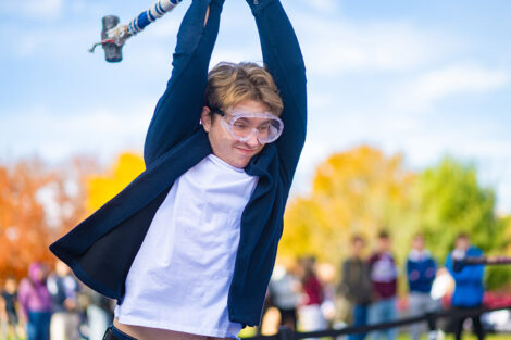 A student uses a sledgehammer on the Lehigh car.