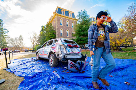 A student uses a sledgehammer on the Lehigh car.