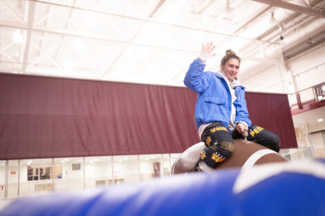 A student rides a mechanical football.