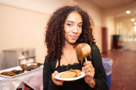 A student smiles with a caramel apple.