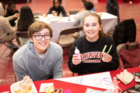 Two students smile, participating in crafts.