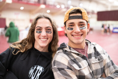 Two students smile