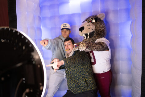 Students pose in a photo booth with the Leopard