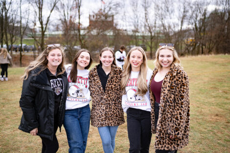 Students smile, wearing leopard, maroon, and white.