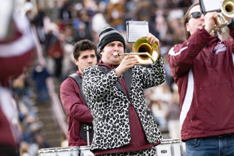 A student in a Leopard jacket plays the trumpet.