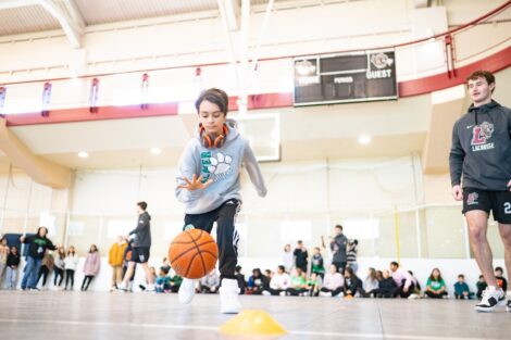 A young student dribbles the basketball during a warm-up game.