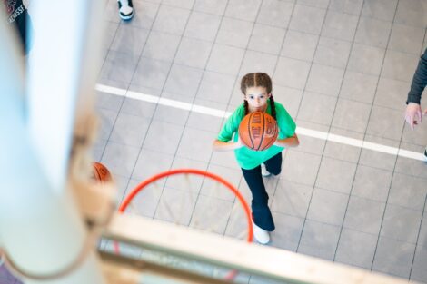 A girl shoots a basket in a hoop.