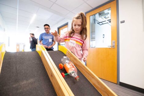 Girl Scout racing a car she built at Lafayette's Girl Scout Badge Day