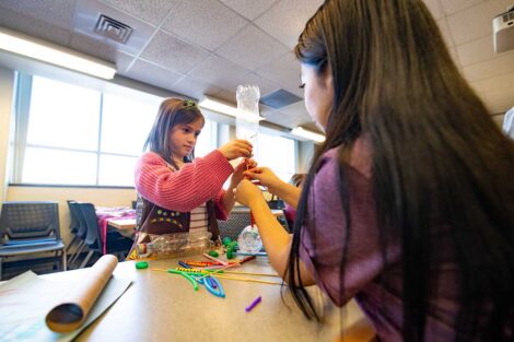 Girl Scout and Lafayette student working on a project together during Girl Scout Badge Day