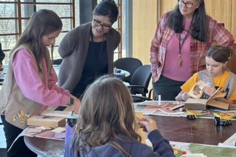 Ana Ramirez Luhrs and Beth Sica help Cadette Scouts on their Book Artist badge.