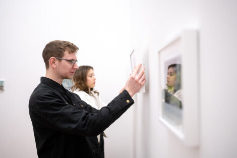 Students hang art in a gallery