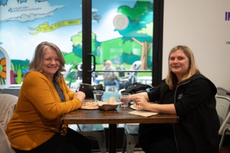 Two Lafayette employees smile as they enjoy lunch at Easton Public Market during Shop Local Day