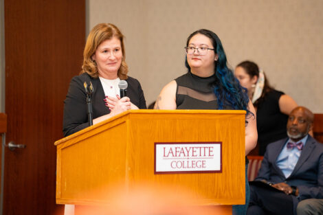 President Hurd speaks beside a student at the Lavender Celebration