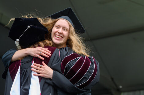A graduate hugs President Hurd.