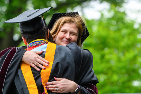 A graduate hugs President Hurd.