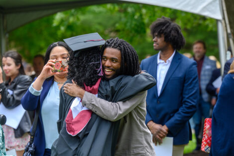 A graduate hugs their family.
