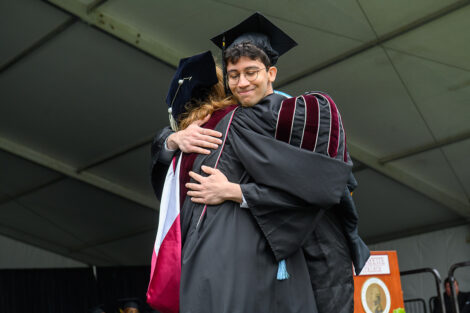 A graduate hugs President Hurd.