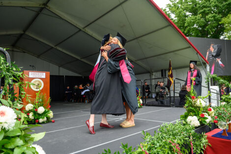 A graduate hugs President Hurd.