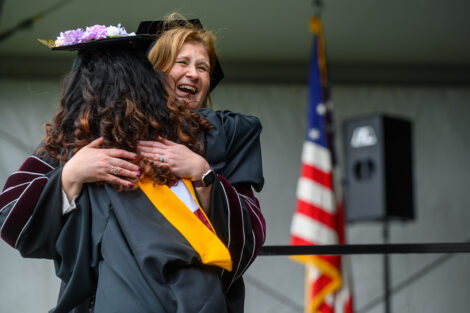 A graduate hugs President Hurd.