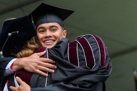 A graduate hugs President Hurd.