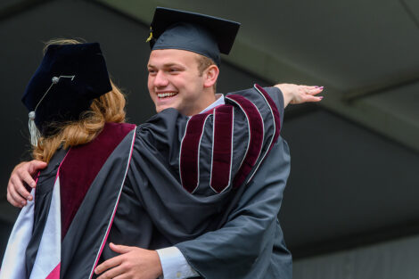 A graduate hugs President Hurd.