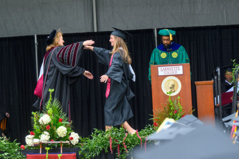 A graduate hugs President Hurd.