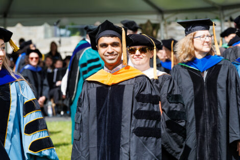 Lead by the Leopard, rows of faculty, staff, and students process into Commencement.