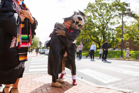 The Leopard hugs a graduate.