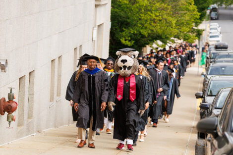 Lead by the Leopard, rows of faculty, staff, and students process into Commencement.