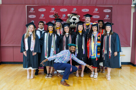 Graduates and Tim Cox pose with the Leopard.