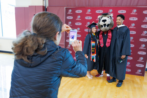 A person takes a photo of graduates with the Leopards.
