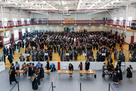 Graduates in the gymnasium getting ready.