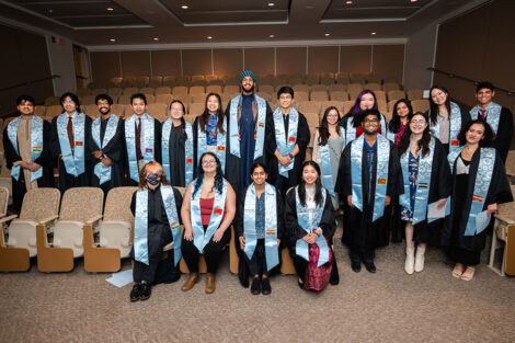 Students, wearing their AAPI stoles, smile in a group photo.