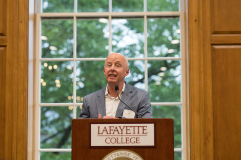 Trustee Chris McCumber '89 stands at a podium. The Lafayette College logo is on the front of the podium.