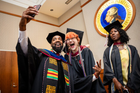 Tim Cox poses for a selfie with two students