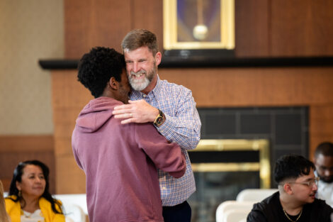 A prof hugs a graduate