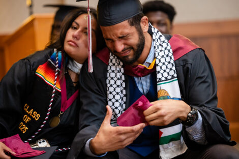 Two students lean on each other, crying, during the Posse celebration