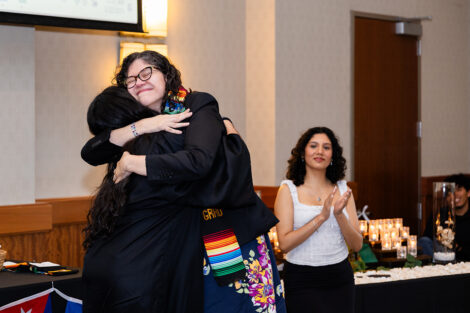 A student hugs a staff member at the Unidos en Celebración