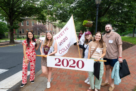 Members of the Class of 2020 are holding banners that read 2020 at the parade.