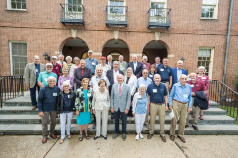A group of alumni pose for their Class picture in front of Marquis Hall.