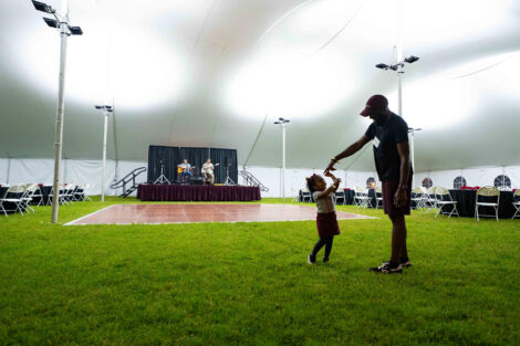 A father and daughter dance under the Quad tent.