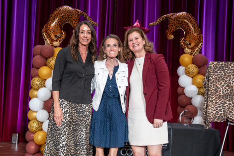 Fran Della Badia '91, Megan Young '13, and Nicole Farmer Hurd are standing arm in arm and smiling at the camera.