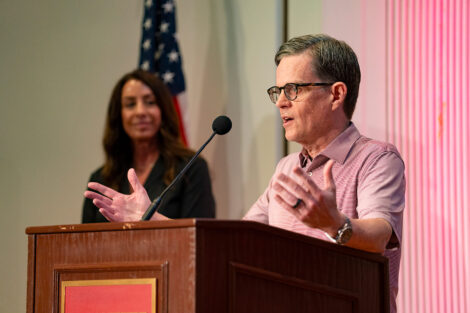 John Mulcahy ’87, P’27, vice president of the alumni association board, stands at a podium.