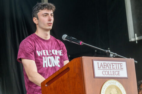Alex Brown speaks at a podium during Convocation.