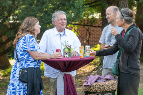 Families chat around a maroon table