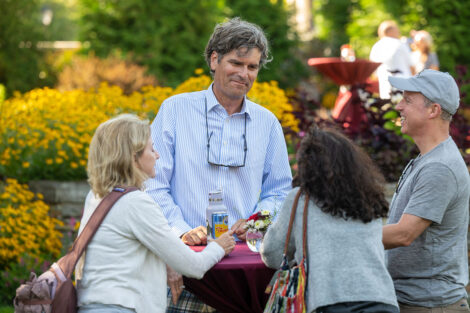 Families chat around a maroon table